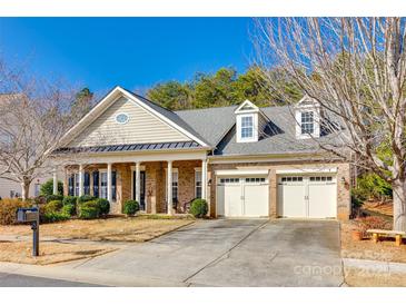 Brick ranch home with three-car garage and front porch at 1380 Secret Path Dr, Fort Mill, SC 29708