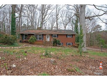 Brick ranch house with mature trees and landscaping at 218 Kingsway Cir, Charlotte, NC 28214