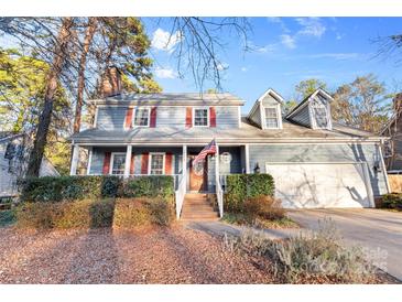 Two-story house with gray siding, red shutters, and a brick walkway at 2512 Heathershire Ln, Matthews, NC 28105