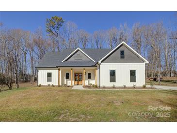 Two-story farmhouse with white siding, gray roof, and a front porch at 2712 Yellow Bell Way, Monroe, NC 28112