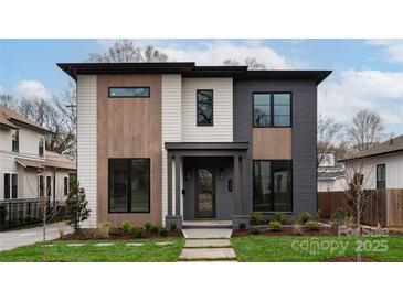 Modern two-story home with gray and white siding, wood accents, and a landscaped lawn at 308 Dover Ave, Charlotte, NC 28209