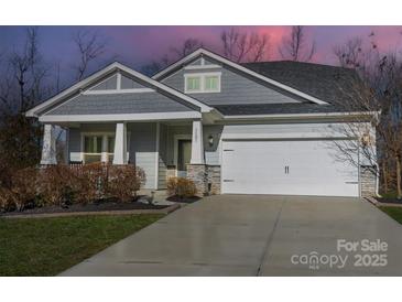 Gray exterior with white garage door, stone accents, and landscaping at 3101 Elmwood Dr, Monroe, NC 28110