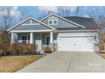 Gray house with white garage door, stone accents, and landscaping at 3101 Elmwood Dr, Monroe, NC 28110