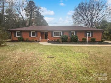 Brick ranch home with landscaped yard and walkway at 4616 Whispering Oaks Dr, Charlotte, NC 28213