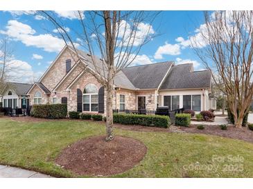 Inviting exterior of charming ranch home with stone accents and landscaped yard at 874 Ledgestone Ct, Tega Cay, SC 29708