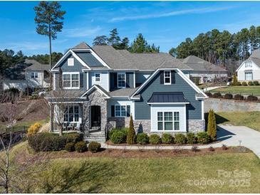 Two-story home with gray siding, stone accents, and a landscaped lawn at 100 S Centurion Ln, Mount Holly, NC 28120