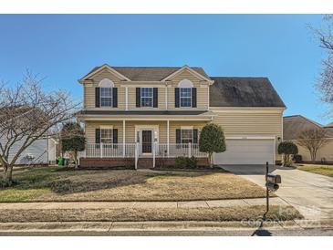 Charming two-story home with a welcoming front porch, attached garage, and well-maintained lawn at 12338 Shadow Ridge Ln, Charlotte, NC 28273