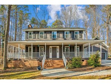 Two-story house with wraparound porch and large backyard at 14264 Maple Hollow Ln, Mint Hill, NC 28227