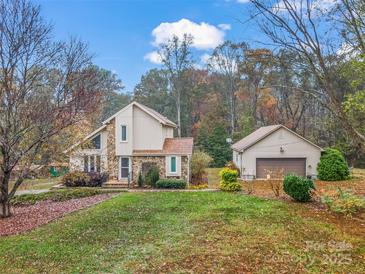 Charming two-story home featuring stone accents, an attached garage, and beautiful landscaping for a welcoming curb appeal at 33287 Mann Rd, Albemarle, NC 28001