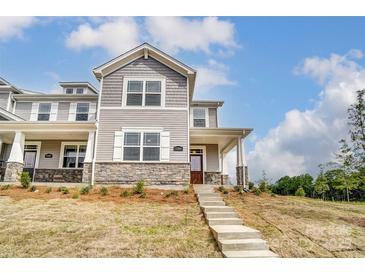 Two-story townhome with gray siding, stone accents, and a covered porch at 4000 Cheyney Park Dr, Charlotte, NC 28269