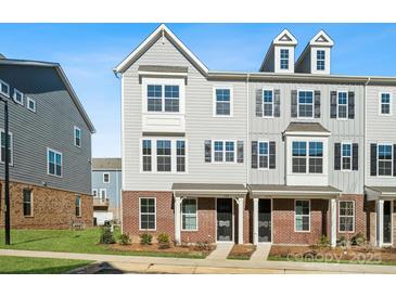 Three-story townhome with gray siding, brick accents, and a covered front porch at 4350 Reed Creek Dr, Sherrills Ford, NC 28673