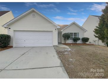 House exterior featuring a white vinyl-sided home with a two-car garage and a small front yard at 811 Reigate Rd, Charlotte, NC 28262