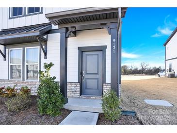 Two-story home with gray and white exterior, landscaping, and walkway at 9131 Nw Harwen Ne Ln # 32, Charlotte, NC 28215