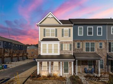 Two-story townhome with brick and siding exterior, featuring a charming front porch at 11043 Lawyers Rd, Mint Hill, NC 28227