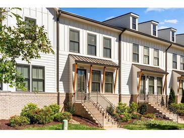 Modern white townhouses with brick accents and landscaping at 11936 Fiddlers Roof Ln, Charlotte, NC 28277