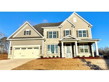 Two-story house with stone accents and a three-car garage at 2558 Red Hill Nw St # 51, Concord, NC 28027