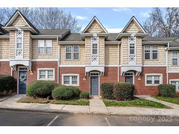 Three-unit townhome building with brick and shingle exterior, and landscaping at 3026 Uxbridge Woods Ct, Charlotte, NC 28205