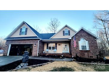 Brick and beige two-story house with attached garage and landscaping at 306 Bluegill Ln, Statesville, NC 28625