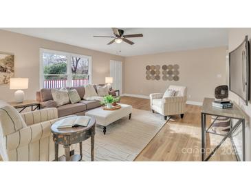 Comfortable living room with a ceiling fan, plush seating, and wood-look flooring at 407 Thomas St, Marshville, NC 28103