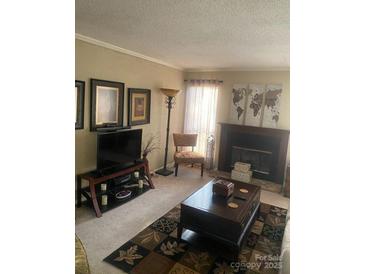 Cozy living room featuring a fireplace, large TV, and comfortable seating at 11306 Kingfisher Dr, Charlotte, NC 28226