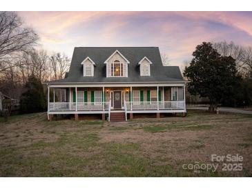 Two-story house with a wraparound porch and landscaped lawn at 2400 Potter Downs Dr, Waxhaw, NC 28173