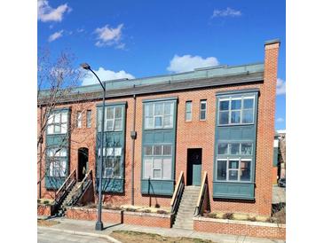 Brick townhomes with stoops, large windows, and painted window frames under a partly cloudy, blue sky at 544 New Bern Station Ct, Charlotte, NC 28209