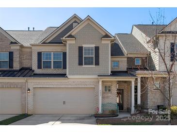 Charming townhome with two-car garage, neutral brick, and stylish gray trim, offering a welcoming curb appeal at 6007 Cadence Ln, Indian Land, SC 29707