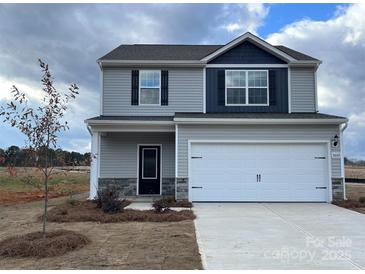 Two-story house with gray siding, white garage door, and stone accents at 3402 Saddlebred Dr, Gastonia, NC 28052