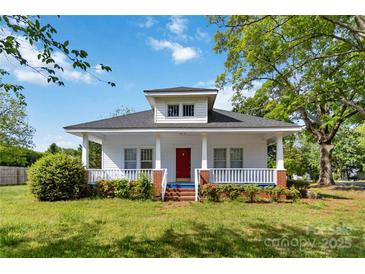 Charming two-story home with a red door and a cozy front porch at 6037 Pleasant Grove Rd, Charlotte, NC 28216