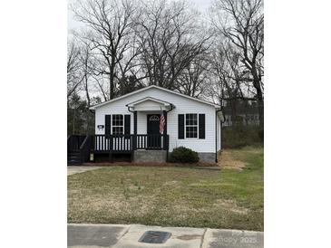 Charming home featuring a welcoming front porch, black shutters, and fresh white siding at 629 S Caldwell St, Salisbury, NC 28144
