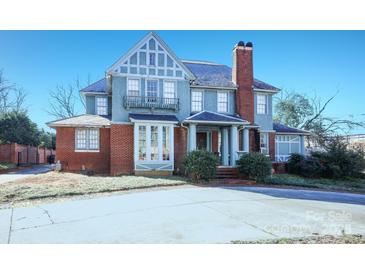 Brick two-story home with a slate roof, large windows, and a spacious front yard at 1024 Queens Rd, Charlotte, NC 28207