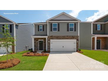 Charming two-story home featuring gray siding, stone accents, a two-car garage, and a well-maintained front yard at 1427 5Th Street Ne Dr, Hickory, NC 28601