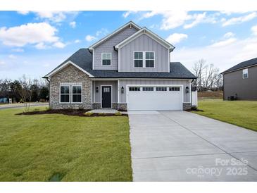 Two-story house with gray siding, stone accents, and a white garage door at 3070 Swallowtail Ln, Kannapolis, NC 28027