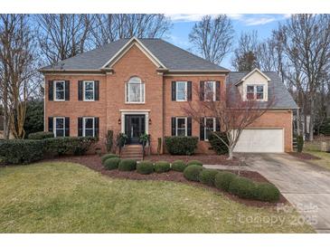 Brick two-story house with a landscaped lawn and attached garage at 8827 Blooming Arbor St, Huntersville, NC 28078