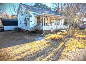 White bungalow with front porch and mature trees at 160 Brookwood Ne Ave, Concord, NC 28025