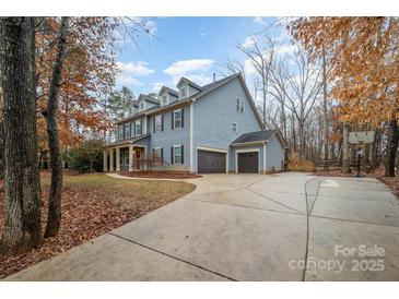 Two-story house with gray siding, red door, and a three-car garage at 2101 Darian Way, Waxhaw, NC 28173