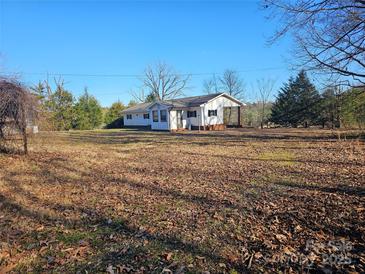 White house with covered porch and large yard at 211 Forgotten Ln, Bessemer City, NC 28016