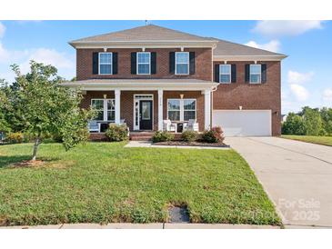 Two story brick home with front porch and landscaped lawn at 2178 Grist Mill Dr, Concord, NC 28025