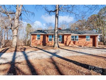 Brick ranch house with large windows and a gravel driveway at 50005 Guy Ln, Norwood, NC 28128