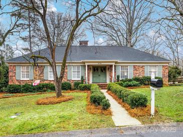 Brick Ranch home with green shutters, landscaped yard, and a walkway at 6716 Ronda Ave, Charlotte, NC 28211