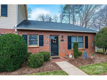 Charming brick home featuring a black front door with wreath, trimmed hedges, and well-maintained landscaping at 749 21St Ne Ave, Hickory, NC 28601