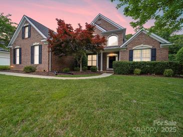 Brick home with landscaping, a walkway, and a spacious lawn at 8100 Avanti Dr, Waxhaw, NC 28173