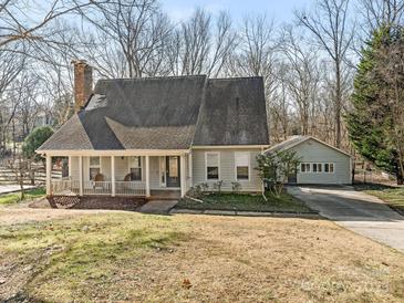 Ranch home with front porch, detached garage, and mature trees on the lot at 8406 Tifton Rd, Charlotte, NC 28226