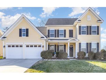 Two-story yellow house with dark shutters, two-car garage, and manicured lawn at 11618 Macallano Dr, Charlotte, NC 28215