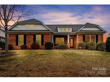 Brick house with a front porch, well-manicured lawn, and a landscaped yard at 130 W Warfield Dr, Mooresville, NC 28115