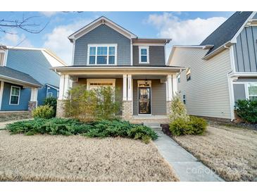 Charming two-story home with a covered front porch and well-maintained landscaping at 13328 Caite Ridge Rd, Davidson, NC 28036