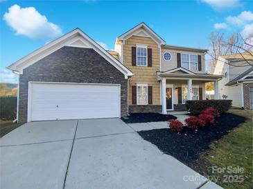 Two-story house with stone and siding exterior, attached garage, and landscaping at 3744 Amber Meadows Dr, Charlotte, NC 28269