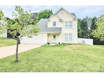 Charming two-story home with a well-maintained lawn, attached garage, and quaint front porch with rocking chairs at 712 Georgie St, Troutman, NC 28166