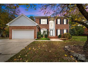 Charming two-story brick home featuring a well-manicured lawn and attached two car garage at 10015 Lattice Ct, Charlotte, NC 28269