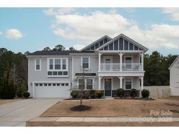 Two-story house with gray siding, a balcony, and a two-car garage at 15209 Red Canoe Way, Charlotte, NC 28278